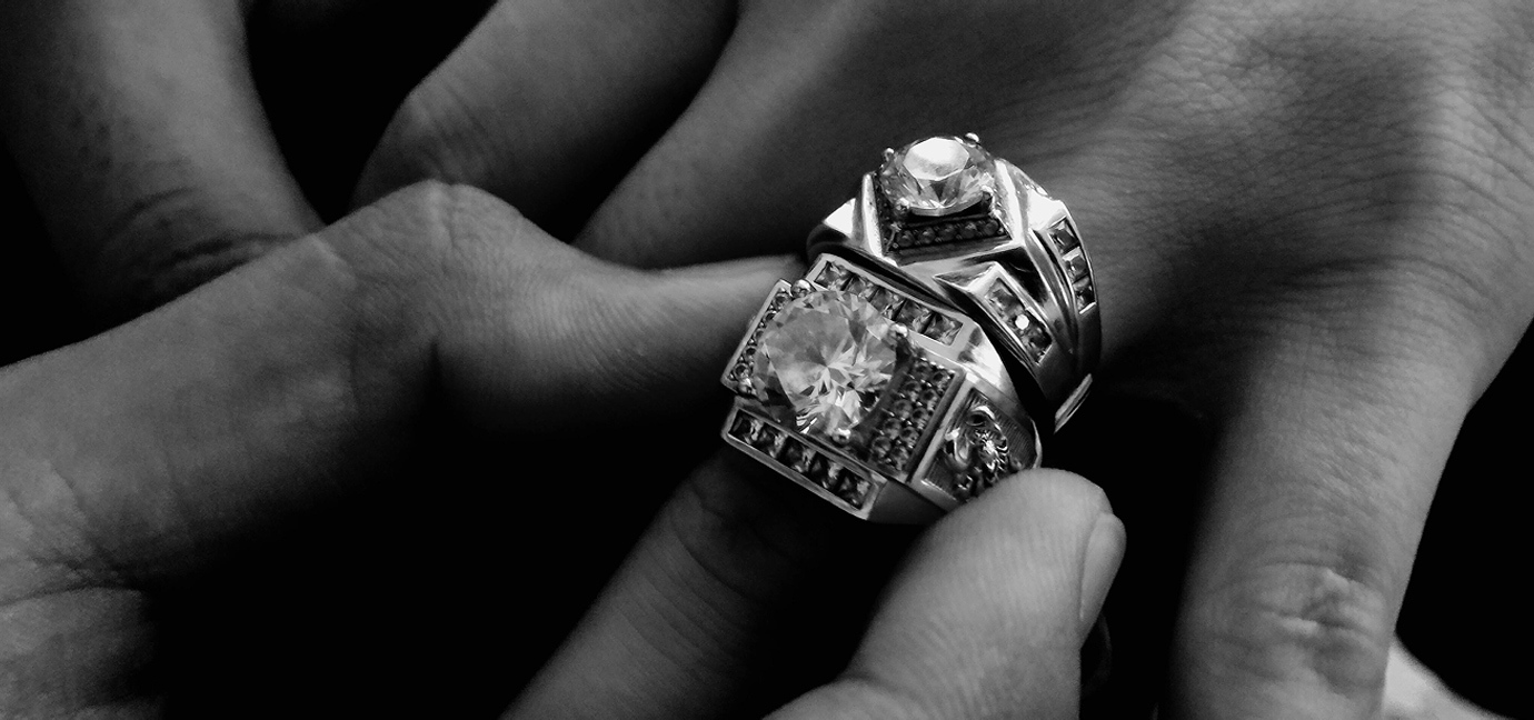 Diamond rings being placed on a hand